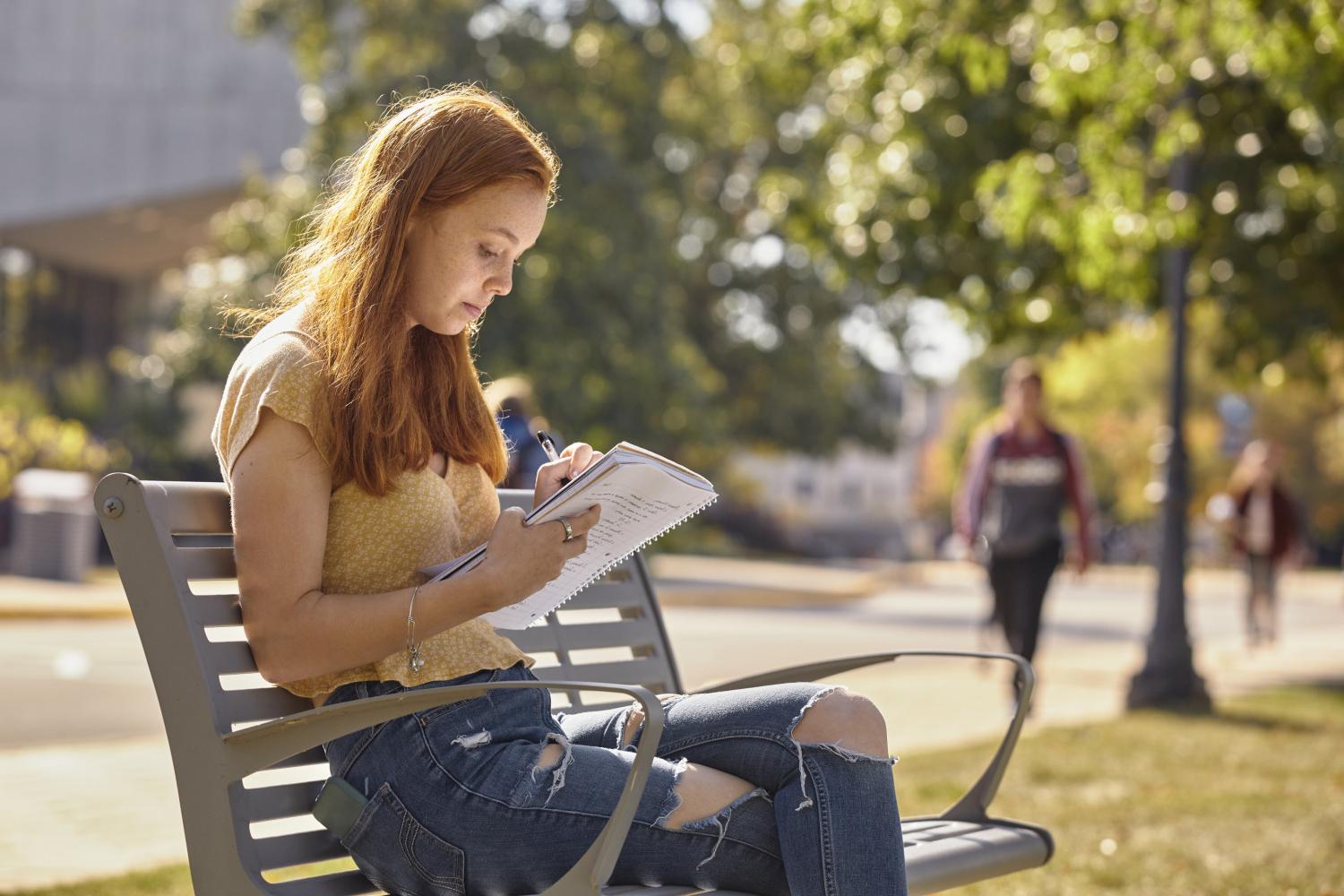 一位<a href='http://z1uh2.goudounet.com'>全球十大赌钱排行app</a>学院的学生在校园里的长椅上读书.